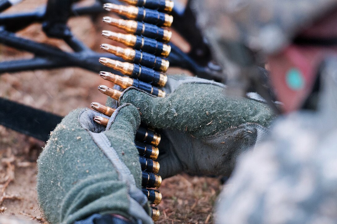 A paratrooper links belts of blank ammunition for an M240B machine gun during an exercise on Fort Bragg, N.C., March 24, 2013.
