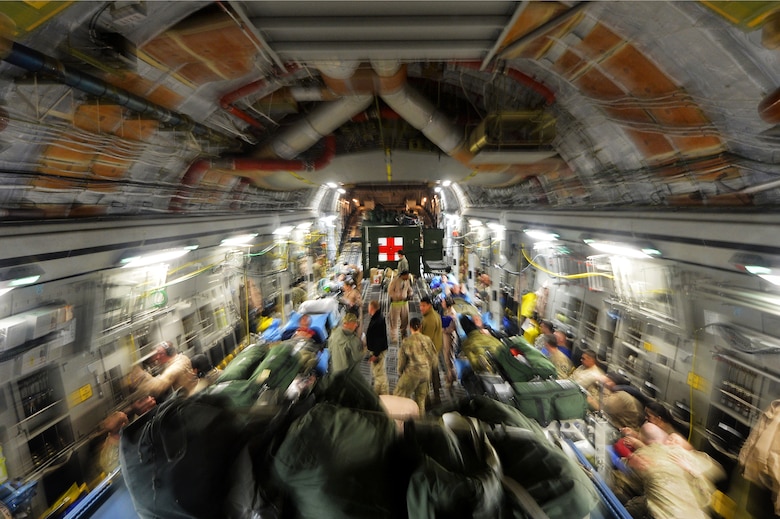 Members of the of the U.S. Air Force 455th Expeditionary Aeromedical Evacuation Squadron assist patients on a C-17 Globemaster III medical transport flight out of Bagram Airfield, Afghanistan, March 21, 2013. With help from the critical care air transport team, the crew can turn a C-17 into a flying intensive care unit to move injured or ill service members by air. (U.S. Air Force photo by Senior Airman Chris Willis)