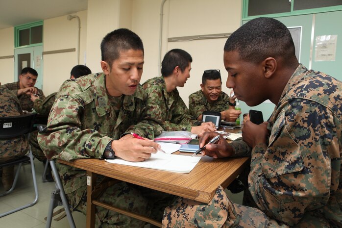 Japan Ground Self-Defense Force Sgt. Mitsugu Tamashiro teaches basic Japanese to Lance Cpl. Jacob L. Crawford during a cultural exchange learning program March 7 at Camp Naha. The two-day program was conducted at both Camp Naha and Camp Kinser. Tamashiro is a is a machine gunner with the 1st Company, 54th Regiment, 15th Brigade. Crawford is a Marine Air Ground Task Force planner with 3rd Marine Logistics Group, III Marine Expeditionary Force.


