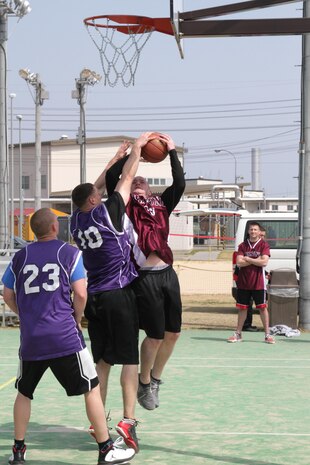 Marines with Marine Wing Support Squadron 171 (purple), and Headquarters and Headquarters
Squadron (red) battle it out in the final round of the Commander’s Cup Basketball Tournament March 23, 2013, on the outdoor basketball court near IronWorks Gym. The tournament ended with MWSS-171 taking home the first-place trophy.