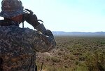 Indiana National Guard Sgt. Brian Clevenger follows a "dust devil" that might be a vehicle through his binoculars while assisting Tucson Sector Border Patrol Agents at an observation post in southern Arizona.