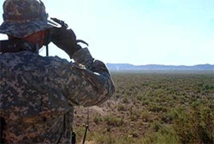 Indiana National Guard Sgt. Brian Clevenger follows a "dust devil" that might be a vehicle through his binoculars while assisting Tucson Sector Border Patrol Agents at an observation post in southern Arizona.