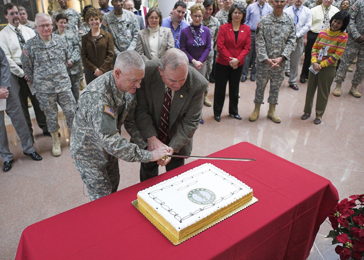 Lt. Gen. Clyde Vaughn, director of the Army National Guard, and Gene McDaniel, who recently surpassed 50 years of federal service, teamed up, with a sword, of course, to cut the cake during the National Guard's 370th birthday Dec. 13 at the Army National Guard Readiness Center in Arlington, Va.