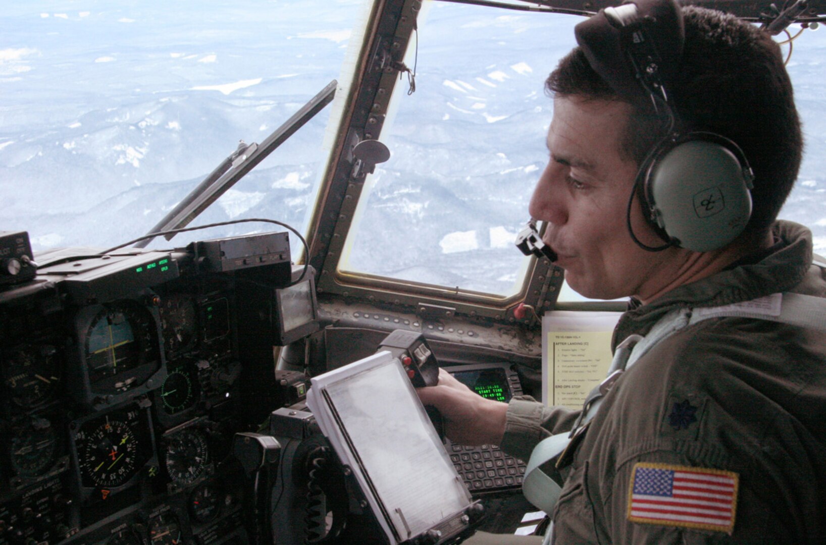 Lt. Col. Caesar Garduno receives coordinates while flying over Mt. Hood, Ore., Dec. 16. Colonel Garduno and his Air National Guard crew were joined by an Air Force Reserve pararescueman searching for three missing climbers. The colonel is a C-130 pilot from the 152nd Airlift Wing in Nevada.
