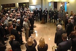 Jason Hall, director of the National Guard educational foundation and National Guard Association of the United States museum curator speaks at the opening of new exhibit that displays National guard artifacts from Operations Enduring Freedom and Iraqi Freedom Dec. 7. The Soldiers and Airman to his left donated the items displayed.