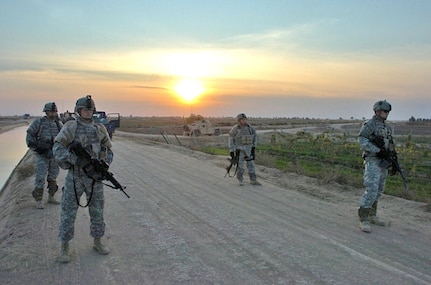 Sgt. Ed Raati of Chisholm, Minn., (left), Sgt. Danny Kraskey of Grand Rapids, Minn., Sgt. Brandon Combs of Horace, N.D., and Staff Sgt. Bradley Lahti of Robbinsdale, Minn., wait for cars to approach them to be searched Dec. 13 near Logistical Support Area Anaconda. All are Soldiers from Company C, 2nd Battalion, 136th Combined Arms Battalion, 1st Brigade Combat Team, 34th Infantry Division.