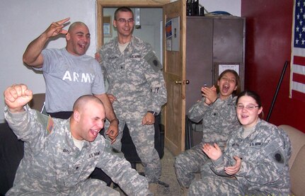 Soldiers from the 1744th Transportation Company celebrate as Chicago Bear Bernard Berrian catches a touchdown pass from quarterback Rex Grossman in the Chicago Bears' victory over the New Orleans Saints in the National Football Conference Championship game, Jan. 21. Pictured are: Spc Daniel Barsi (front left raising his fist in the air), Staff Sgt. Joseph Geymayel (back left), Spc. Kyle Hollingsworth (in the doorway), Spc. Annette Uriostegui (back right), and Spc. Brianna Mariani.