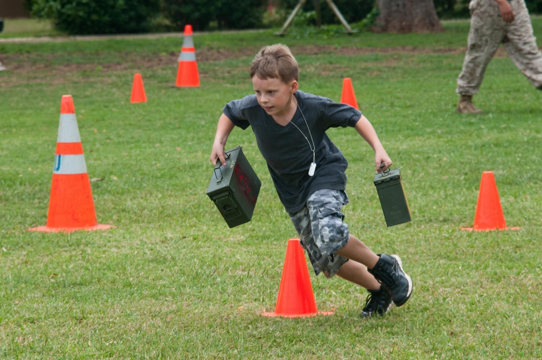 MARINE CORPS BASE HAWAII — One of several participants of Operation Ooh-rah Kids races through the modified Combat Fitness Test course, March 22, 2013. Children ran with ammo cans and threw water-soaked toys before crawling to the finish line. (U.S. Marine Corps photo by Christine Cabalo)