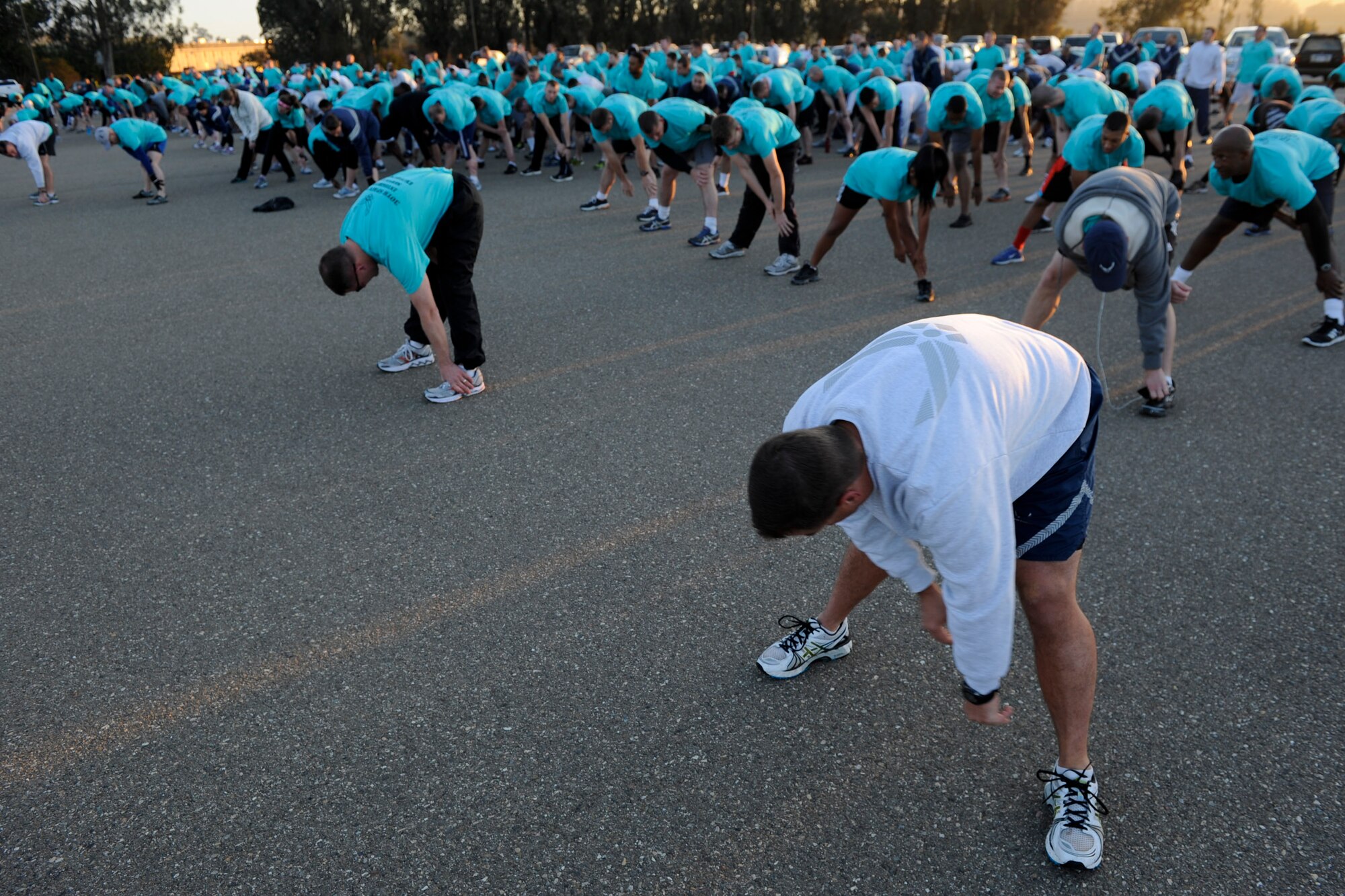 VANDENBERG AIR FORCE BASE, Calif. -- Team V members stretch before the monthly Fit-to-Fight Run here Friday, March 29, 2013. Runners were encouraged to wear blue and teal T-shirts, representing Child Abuse Awareness Month and Sexual Assault Awareness Month respectively. (U.S. Air Force photo/Staff Sgt. Levi Riendeau)

