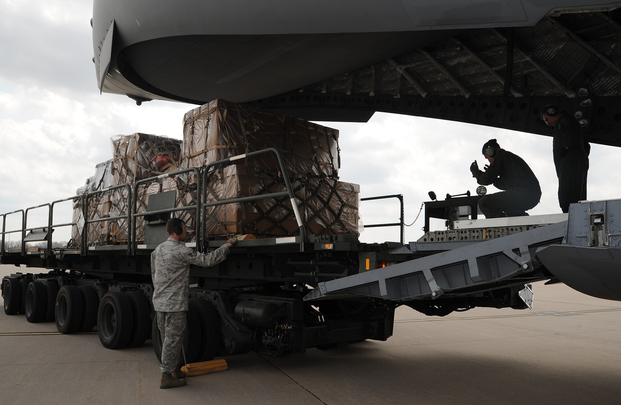 Airmen from the 22nd Logistics Readiness Squadron assist loadmasters in loading three pallets onto a C-17 Globemaster III assigned to March Air Reserve Base, Calif., March 29, 2013, McConnell Air Force Base, Kan. The pallets included nearly five-tons of surplus equipment can no longer be used in Kansas due to its age or changes in state regulations, and is being sent to the Corps of Volunteer Firefighters of Paraguay. (U.S. Air Force photo/Senior Airman Katrina M. Brisbin)