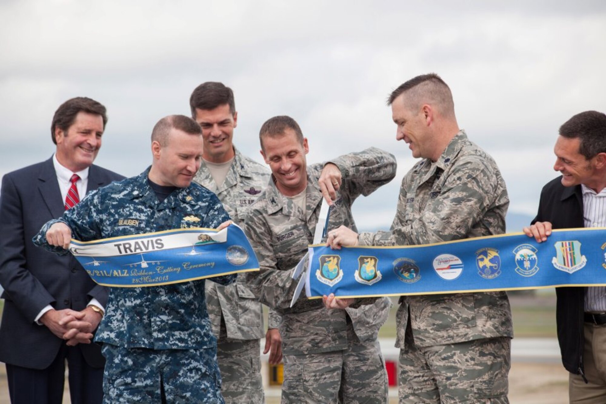 TRAVIS AIR FORCE BASE, Calif. -- Col. Matthew J. Burger, 349th Air Mobility Wing commander, together with military and civilian officials, completes the two-part ribbon cutting ceremony opening here on reconstruction runway 3R-21L, March 28, 2013. (U.S. Air Force photo / Lt. Col. Robert Couse-Baker)
