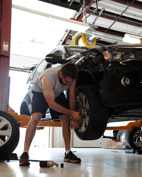Aaron Lucas, spouse of Capt. Carrie Lucas, 2nd Medical Operations Squadron, changes a tire at the Auto Hobby Shop on Barksdale Air Force Base, La., March 29. The shop provides various tools and equipment used for car maintenance. (U.S. Air Force photo/Airman 1st Class Benjamin Gonsier)