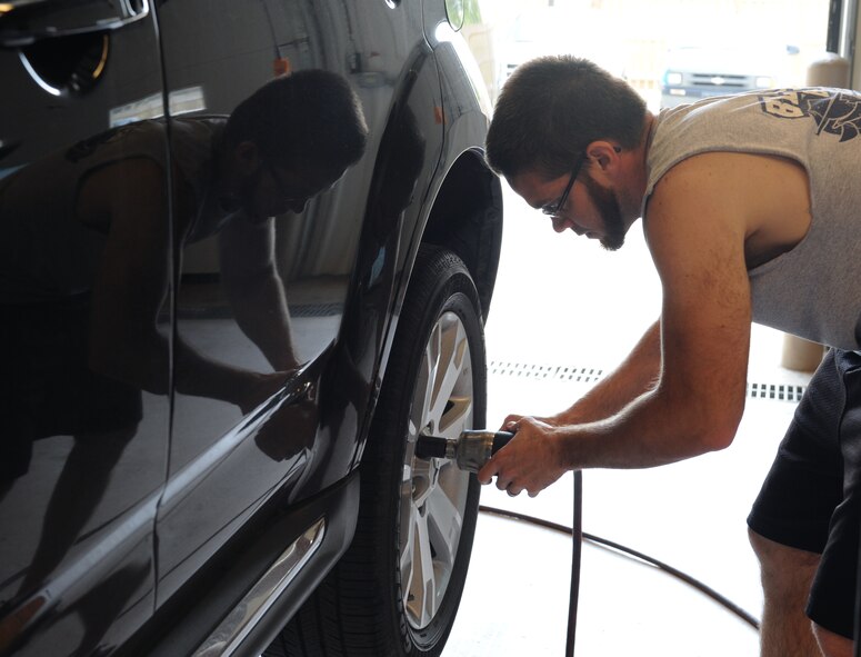 Aaron Lucas, spouse of Capt. Carrie Lucas, 2nd Medical Operations Squadron, removes a lug nut from a wheel at the Auto Hobby Shop on Barksdale Air Force Base, La., March 29. The shop provides various tools and equipment used for car maintenance. (U.S. Air Force photo/Airman 1st Class Benjamin Gonsier)