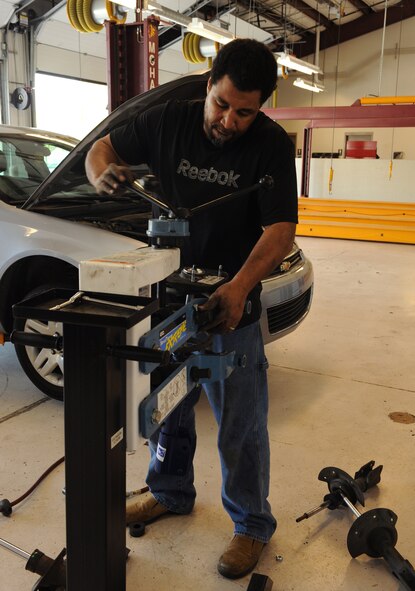 Retired Master Sgt. Andre Cook, 49th Test and Evaluation Squadron, compresses a strut at the Auto Hobby Shop on Barksdale Air Force Base, La., March 29. A strut is a structural element used to brace or strengthen a framework by resisting longitudinal compression. (U.S. Air Force photo/Airman 1st Class Benjamin Gonsier)