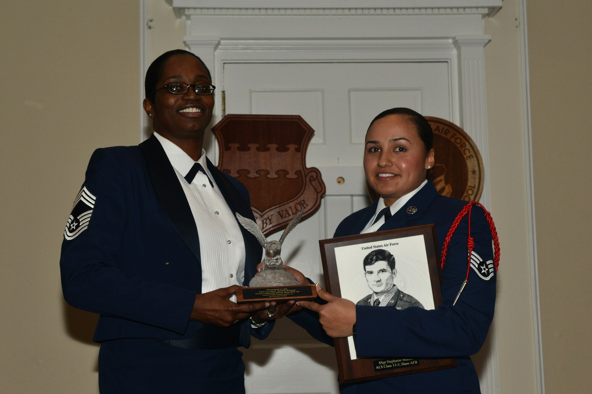 U.S. Air Force Chief Master Sgt. Juanita Osby, 20th Comptroller Squadron superintendent, awards Staff Sgt. Stephanie Munoz, 480th Intelligence, Surveillance and Reconnaissance Wing terrestrial NCO in charge, the John Levitow Award, Shaw Air Force Base, S.C., March 28, 2013. The John Levitow Award is earned by the person with the highest average of instructor and student points and is the highest award in enlisted Professional Military Education. (U.S. Air Force photo/Airman 1st Class Ashley L. Gardner/Released)