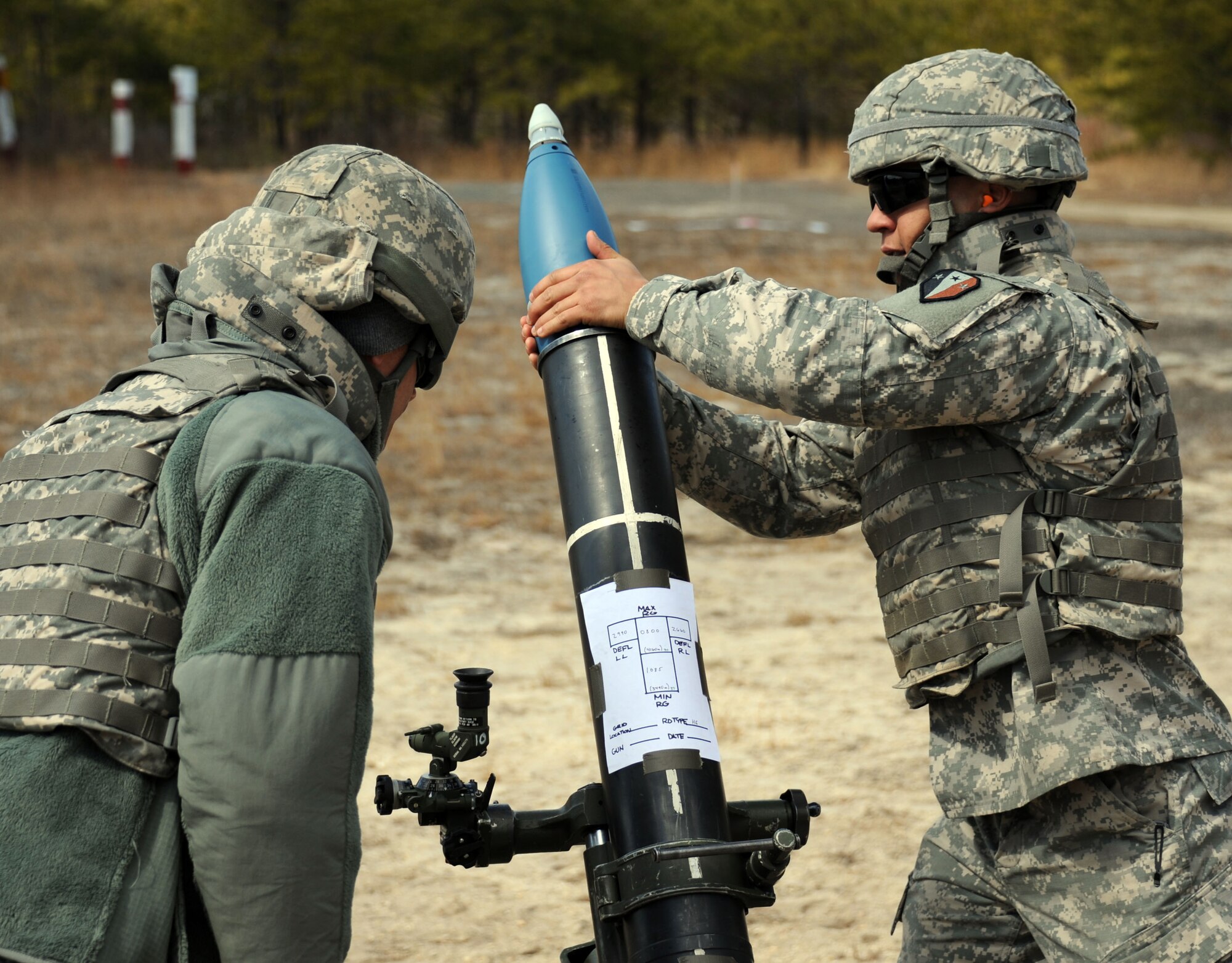 Pvt. Frank Barber, gunner, observes Pvt. Dillon Card, assistant gunner, as he hangs the mortar round prior to firing during mortar firing training on Mortar Firing Point 4 March 23, 2013, at Joint Base McGuire-Dix-Lakehurst, N.J. The New Jersey National Guard Soldiers are both with the 2nd Battalion, 113th Infantry Regiment, Mortar Platoon and hail from Perth Amboy, N.J., and Freehold, N.J., respectively. The unit is based out of Riverdale, N.J. (U.S. Air Force photo by 2nd Lt. David J. Murphy/Released)