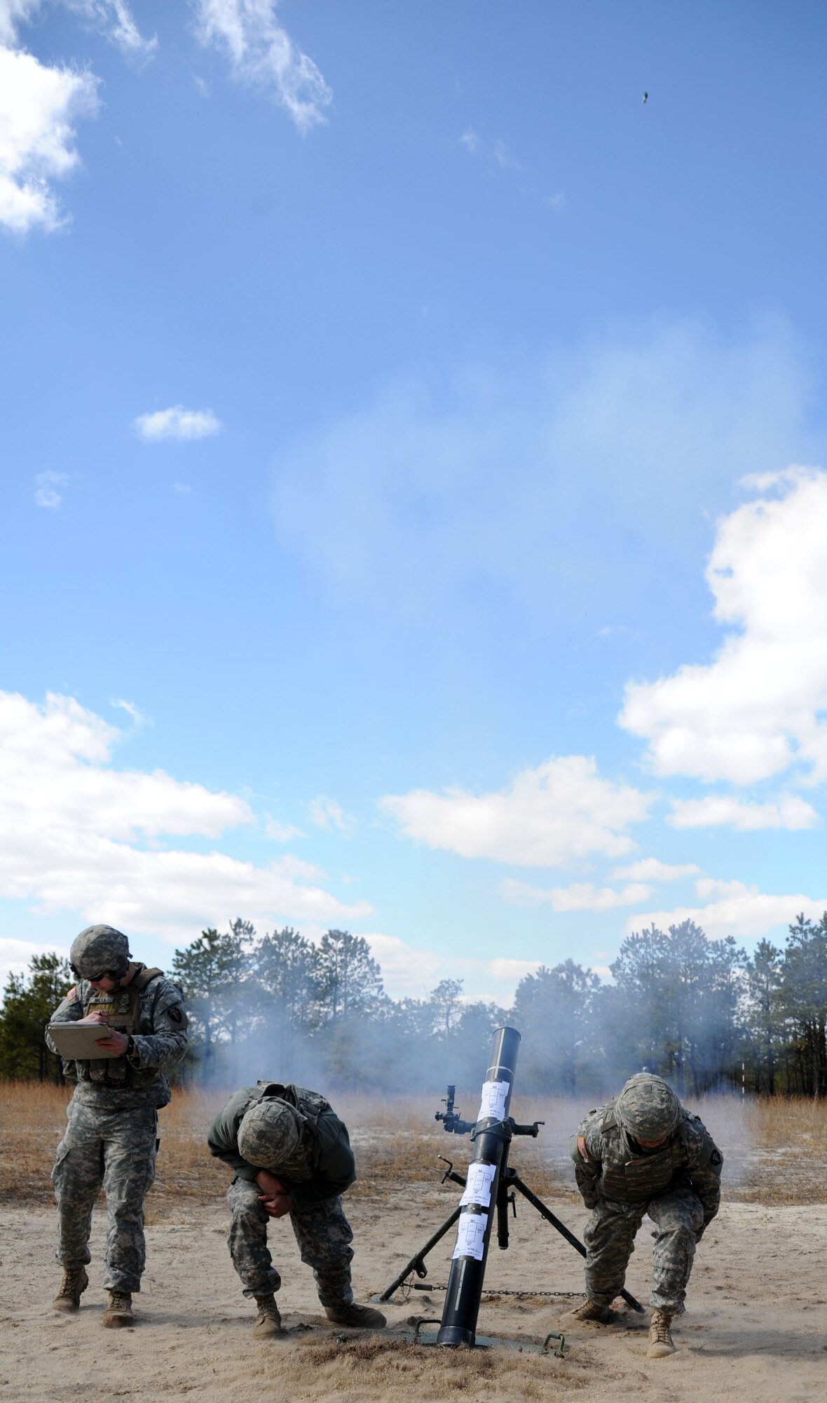 Members of the New Jersey National Guard’s 2nd Battalion, 113th Infantry Regiment, Mortar Platoon, cover their ears as a 120mm mortar round fires during mortar firing training on Mortar Firing Point 4 March 23, 2013, at Joint Base McGuire-Dix-Lakehurst, N.J. Mortar firing training took place from March 22-24 as part of the brigade’s annual training. The unit is based out of Riverdale, N.J. (U.S. Air Force photo by 2nd Lt. David J. Murphy/Released)