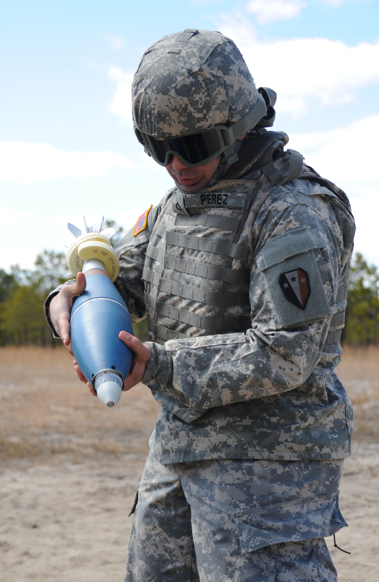 New Jersey National Guard Pfc. Leoneo Perez, 2nd Battalion, 113 Infantry Regiment, Mortar Platoon ammo bearer, prepares a 120mm mortar round for use during mortar firing training on Mortar Firing Point 4 March 23, 2013, at Joint Base McGuire-Dix-Lakehurst, N.J. Perez, an Elizabeth, N.J., native, gave the mortar round to the assistant gunner for placement into the mortar. The unit is based out of Riverdale, N.J. (U.S. Air Force photo by 2nd Lt. David J. Murphy/Released)