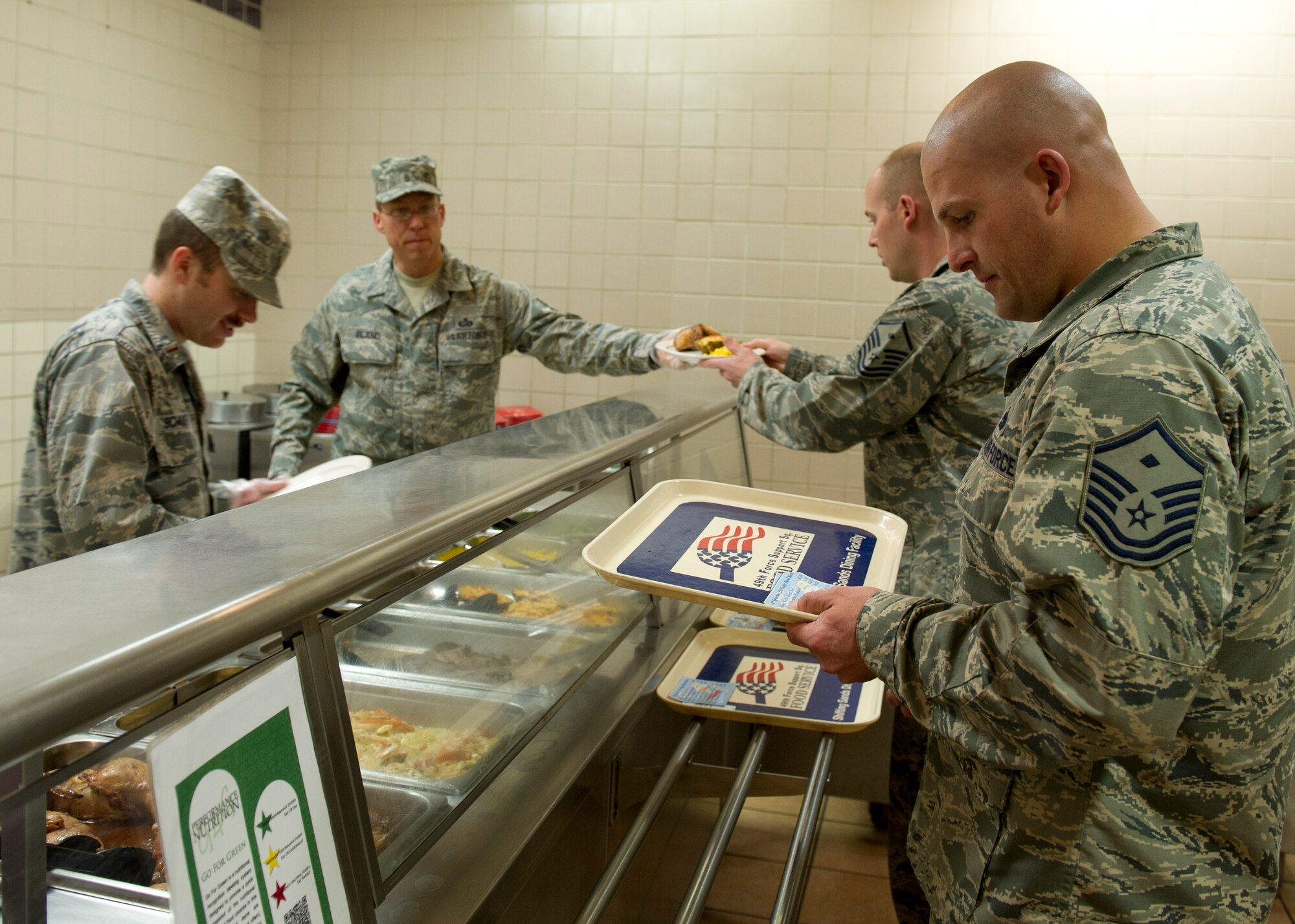 Master Sgt. Patrick Paul, 49th Force Support Squadron first sergeant, reads an Airman’s meal choices as 2nd Lt. Nathan Schultz, 49th FSS chief of food operations, plates the food during the first quarter birthday meal celebration at the Shifting Sands Dining Facility at Holloman Air Force Base, N.M., March 28. Airmen born between the months of January and March were invited to attend the celebration. (U.S. Air Force photo by Senior Airman Kasey Close/Released)