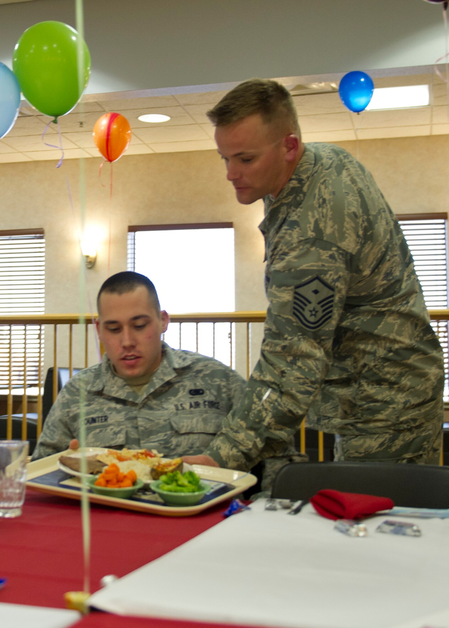 Master Sgt. Tracy Wolfe, 49th Logistics Readiness Squadron first sergeant, serves Airman 1st Class Thomas Counter, 49th LRS equipment manager, his meal during the first quarter birthday meal celebration at the Shifting Sands Dining Facility at Holloman Air Force Base, N.M., March 28. First sergeants and chief master sergeants volunteered to serve all Airmen who attended the celebration. (U.S. Air Force photo by Senior Airman Kasey Close/Released)