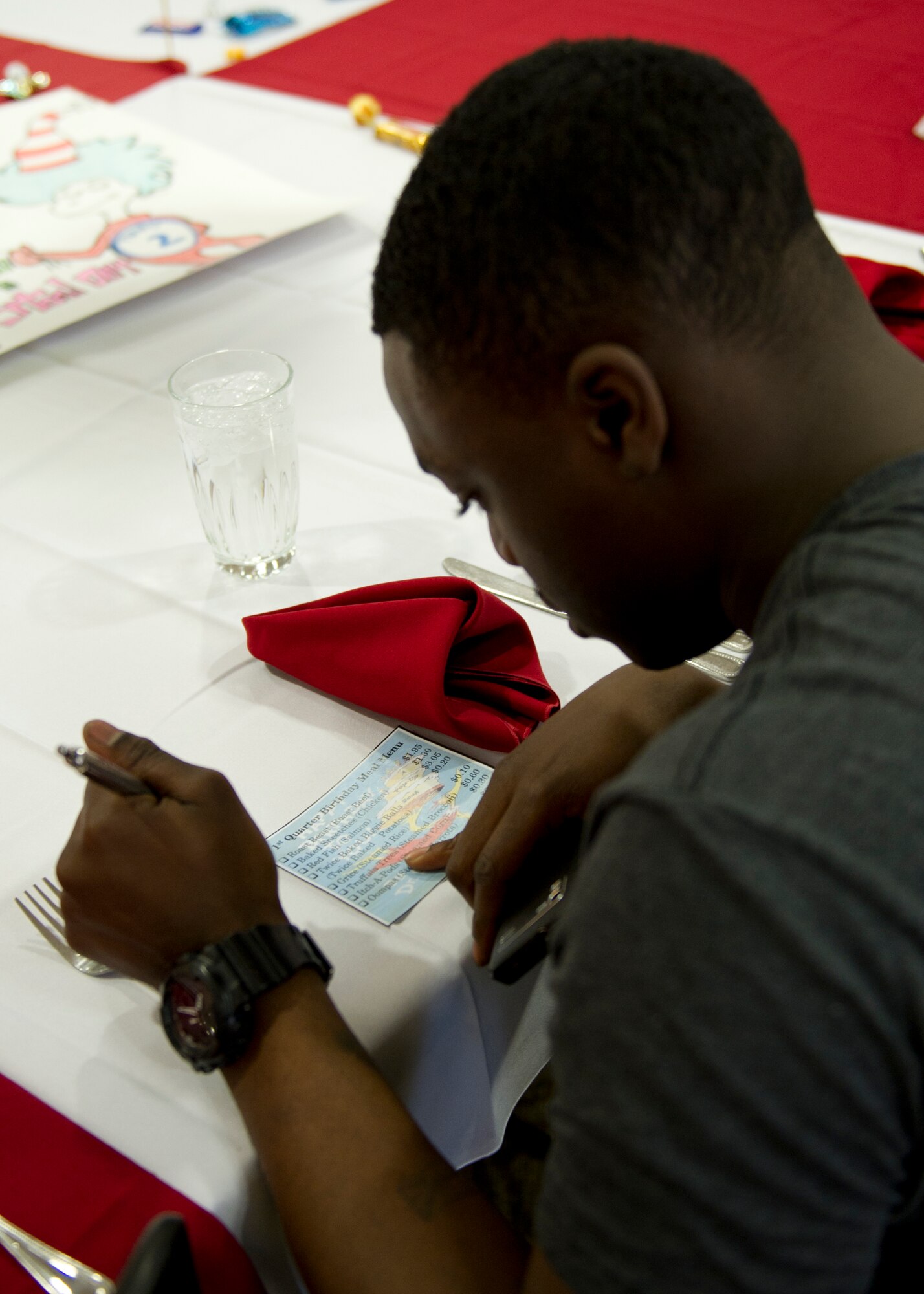 Airman 1st Class Kevin Jenkins, 49th Aircraft Maintenance Squadron F-22 Raptor crew chief, looks at the menu for the first quarter birthday meal celebration at the Shifting Sands Dining Facility at Holloman Air Force Base, N.M., March 28. Airmen born between the months of January and March were invited to attend the celebration. (U.S. Air Force photo by Senior Airman Kasey Close/Released)