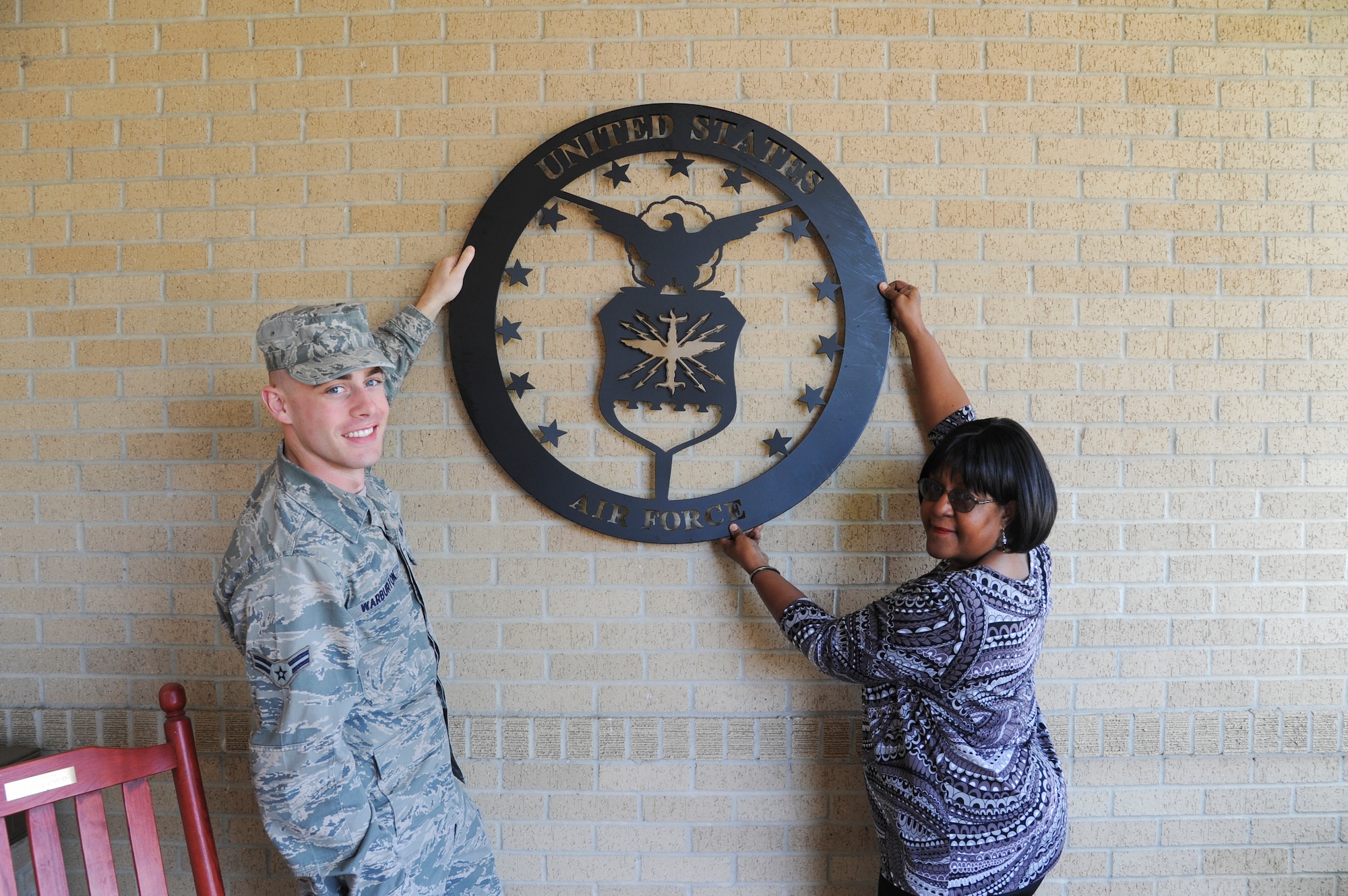 U.S. Air Force Airman 1st Class Westin Warburton, Air Force Public Affairs Agency photographer, displays a donated United States Air Force emblem with Ms. Ramona Lewis, Lackland Fisher Houses manager, at Joint Base San Antonio-Lackland, Texas, March 25, 2013. The average stay at a Fisher House is 16 days and the longest stay is 358. (U.S. Air Force photo by Senior Airman Grovert Fuentes-Contreras)