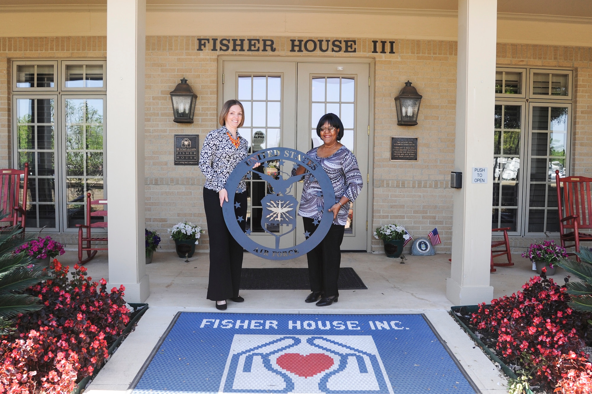 Ms. April Rowden (left), Air Force Trademark and Licensing chief, presents a United States Air Force emblem to Ms. Ramona Lewis, Lackland Fisher Houses manager, at Joint Base San Antonio-Lackland, Texas, March 25, 2013. The average stay at a Fisher House is 16 days and the longest stay is 358. (U.S. Air Force photo by Senior Airman Grovert Fuentes-Contreras)