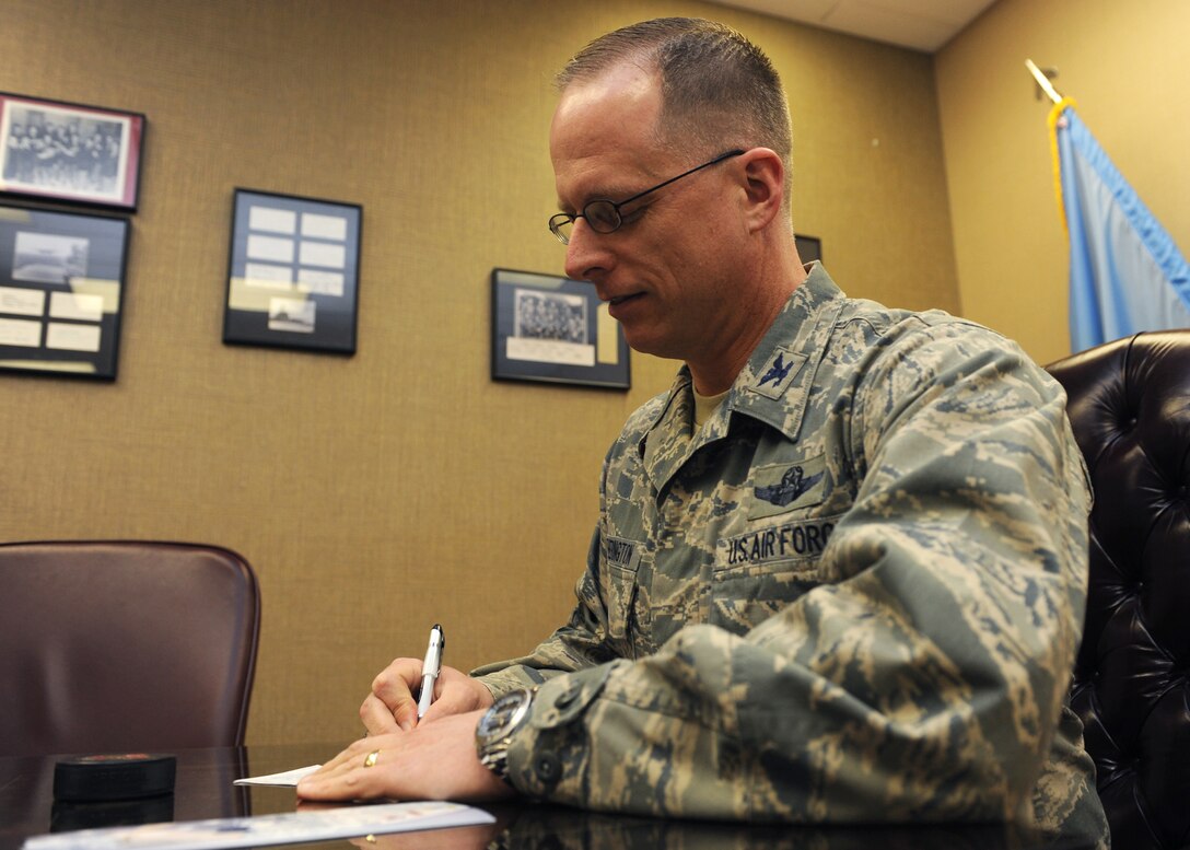 Col. Mark Weatherington, 28th Bomb Wing commander, signs the first pledge to kick off the 2013 Air Force Assistance Fund campaign at Ellsworth Air Force Base, S.D., March 27, 2013. The AFAF was established to raise funds and provide support to Airmen in need, their families, and those of retired Air Force members. (U.S. Air Force photo by Airman 1st Class Alystria Maurer/Released)