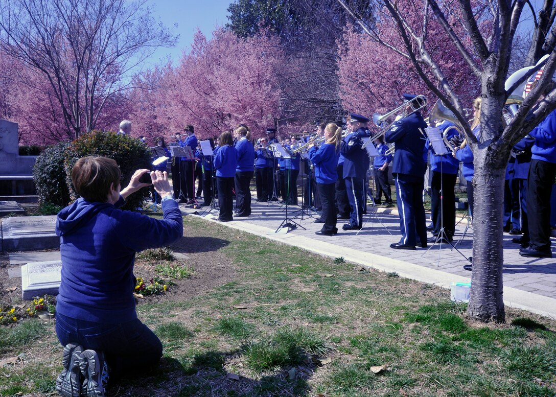 Unaware that their photo is being taken, a band parent snaps a picture of The Wynford High School Band during a performance with the U.S. Air Force Band March 23, 2013, at Congressional Cemetery in Washington, D.C. Together, the bands paid tribute to composer John Philip Sousa by playing some of the composer's famous marches in front of his gravesite. (U.S. Air Force photo/Senior Airman Lindsey A. Porter)
