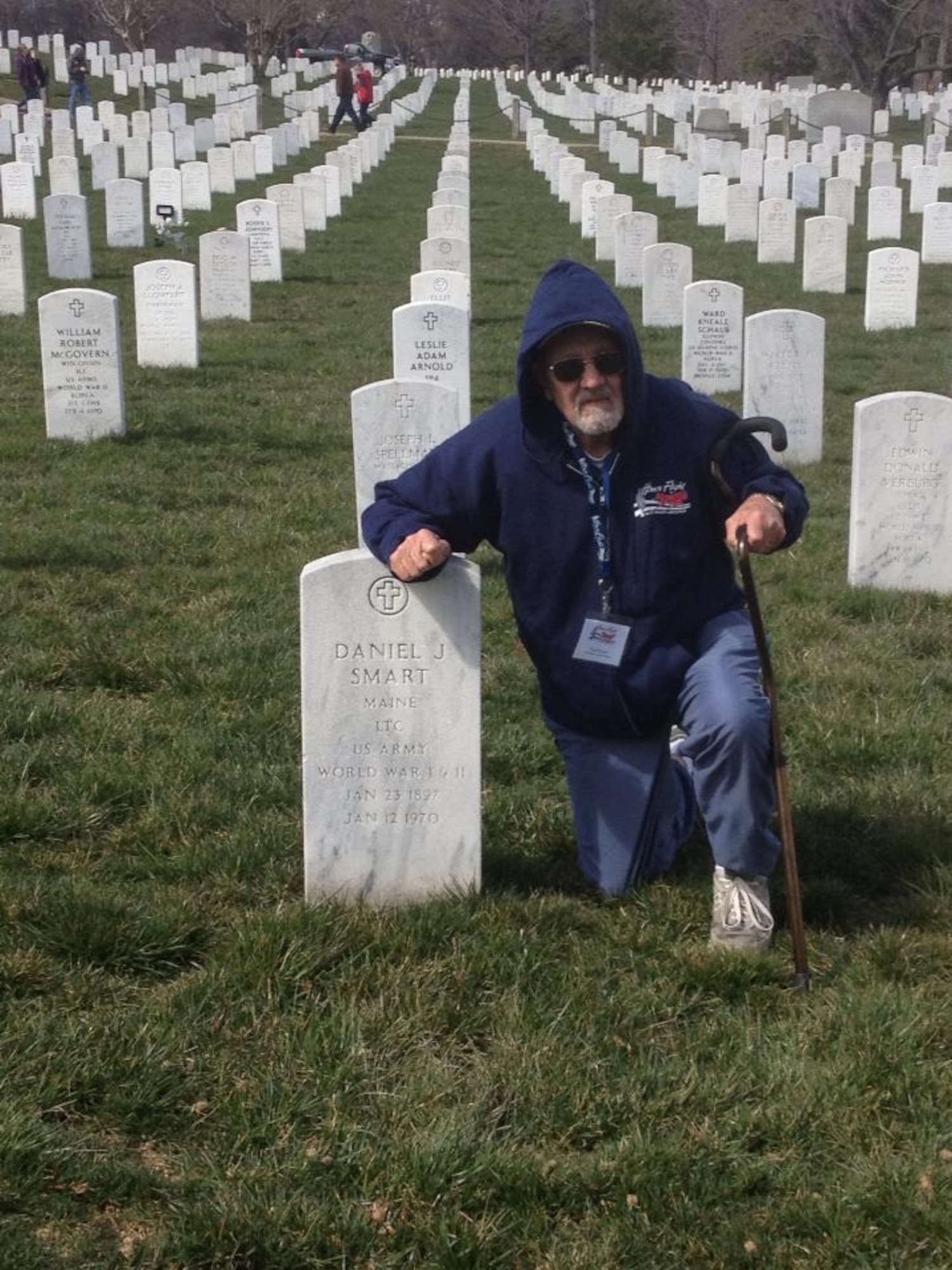 U.S. Air Force retired WWII veteran Thomas Perrow kneels next his godfathers tombstone at the Arlington National Cemetery in Arlington, Va. March 27, 2013. (Courtesy Photo)