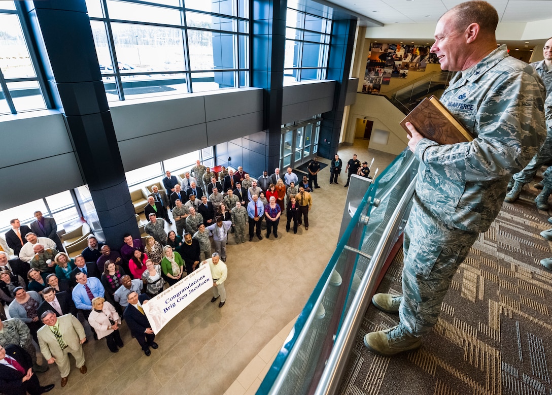 Brig. Gen. Kevin J. Jacobsen, OSI commander, looks down on an assembled group of OSI members at OSI headquarters in Quantico, Va. The group had gathered to congratulate the general for his invitation to the Order of the Sword March 29. Jacobsen is holding his official invitation to the order in his hands. (U.S. Air Force photo/Mike Hastings)