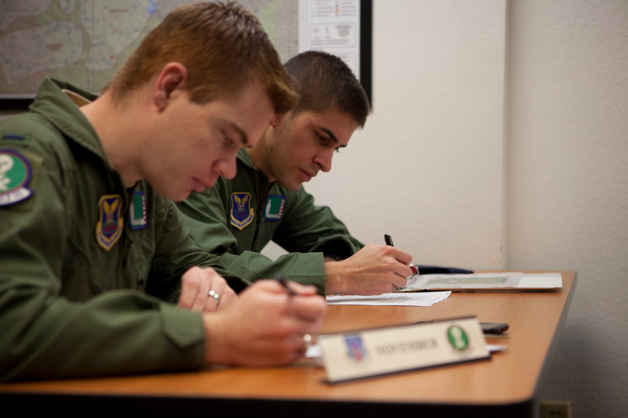 First Lt. Nate Larson, 321st Missile Squadron ICBM combat crew commander, and 2nd Lt. Mark Halling, 321st MS ICBM deputy combat crew commander, take a quiz in the 90th Operations Group March 25 to prepare for the 90th Missile Wing's upcoming Nuclear Surety Inspection. The quiz covers information the missileers should know to pass the NSI (U.S. Air Force photo by 2nd Lt. Christen Downing)