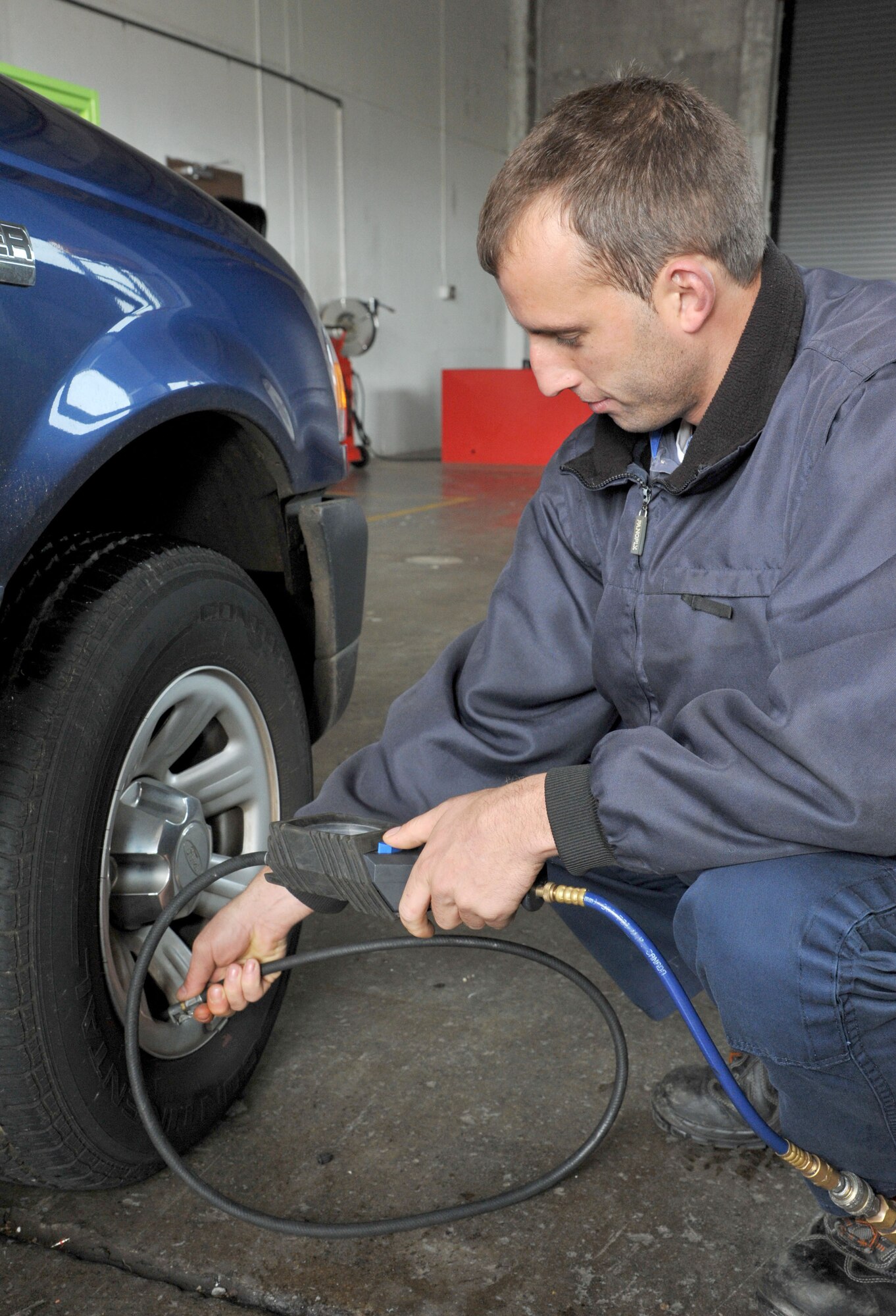Eduardo Ponto Graca, 65th Logistics Readiness Squadron, vehicle mechanic, checks the tire pressure before signing the vehicle out to a customer at Lajes Field, Azores, Mar. 18, 2013.  The vehicle maintenance section performs routine maintenance and inspections on 123 vehicles per month. (Photo by Guido Melo)  