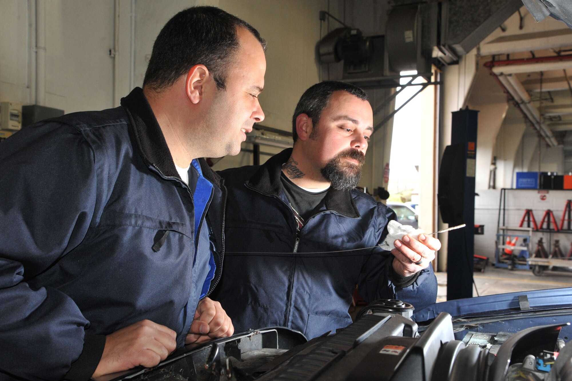 Marco Brasil and Fernando Sousa, 65th Logistics Readiness Squadron, vehicle mechanics, perform daily maintenance checks on their vehicle fleet at Lajes Field, Azores, Mar. 18, 2013. The vehicle maintenance section performs routine maintenance and inspections on 123 vehicles per month. (Photo by Guido Melo)  