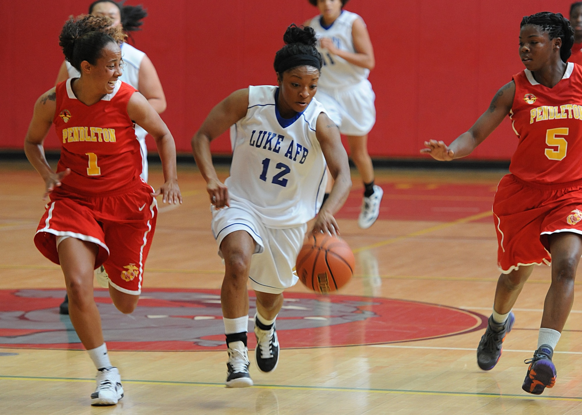 Stephanie Williams, civilian, brings the ball up the court during a game against Camp Pendleton at the Pacific West League Championship Tournament March 24 at the Marine Corps Base Camp Pendleton Fitness Center gym, Calif. Williams sprinted down the court and scored two points for the Lady Falcons. Luke won 65-44. The Lady Falcons finished the tournament in second place after falling short in the finals 86-78 against the Las Vegas Heat. (U.S. Air Force photo/Airman 1st Class Devante Williams)