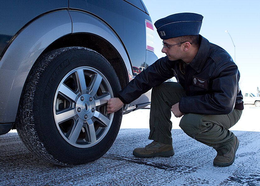 Capt. Aaron Alam, 321st Missile Squadron ICBM deputy combat crew commander, checks the tires to their vehicle prior to departing base for the missile alert facility. (U.S. Air Force photo by 2nd Lt. Christen Downing)