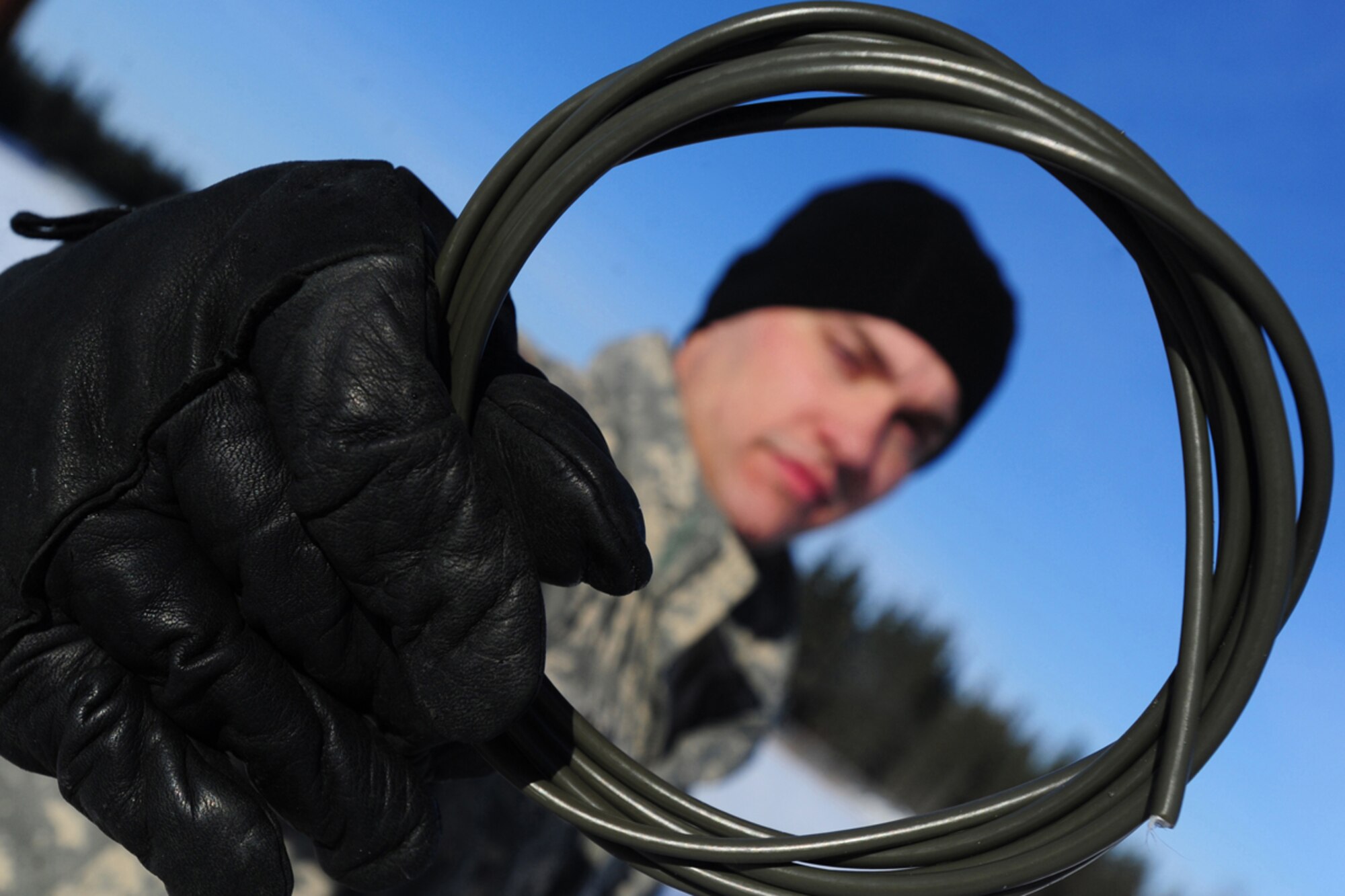 JOINT BASE ELMENDORF-RICHARDSON, Alaska -- Pvt. Zachary Price, left, a native of Mont Belvieu, Texas, holds up a roll of detonating cord before a demolitions exercise. Soldiers assigned to A Company, 425th Brigade Special Troops Battalion, rigged trees with C-4 plastic explosive during a training exercise at Forward Operating Base Sparta on Joint Base Elmendorf-Richardson, March 21, 2013. The exercise allowed the Soldiers to train with demolitions and taking down trees to block enemy advance on roadways. (U.S. Air Force photo/Justin Connaher)
