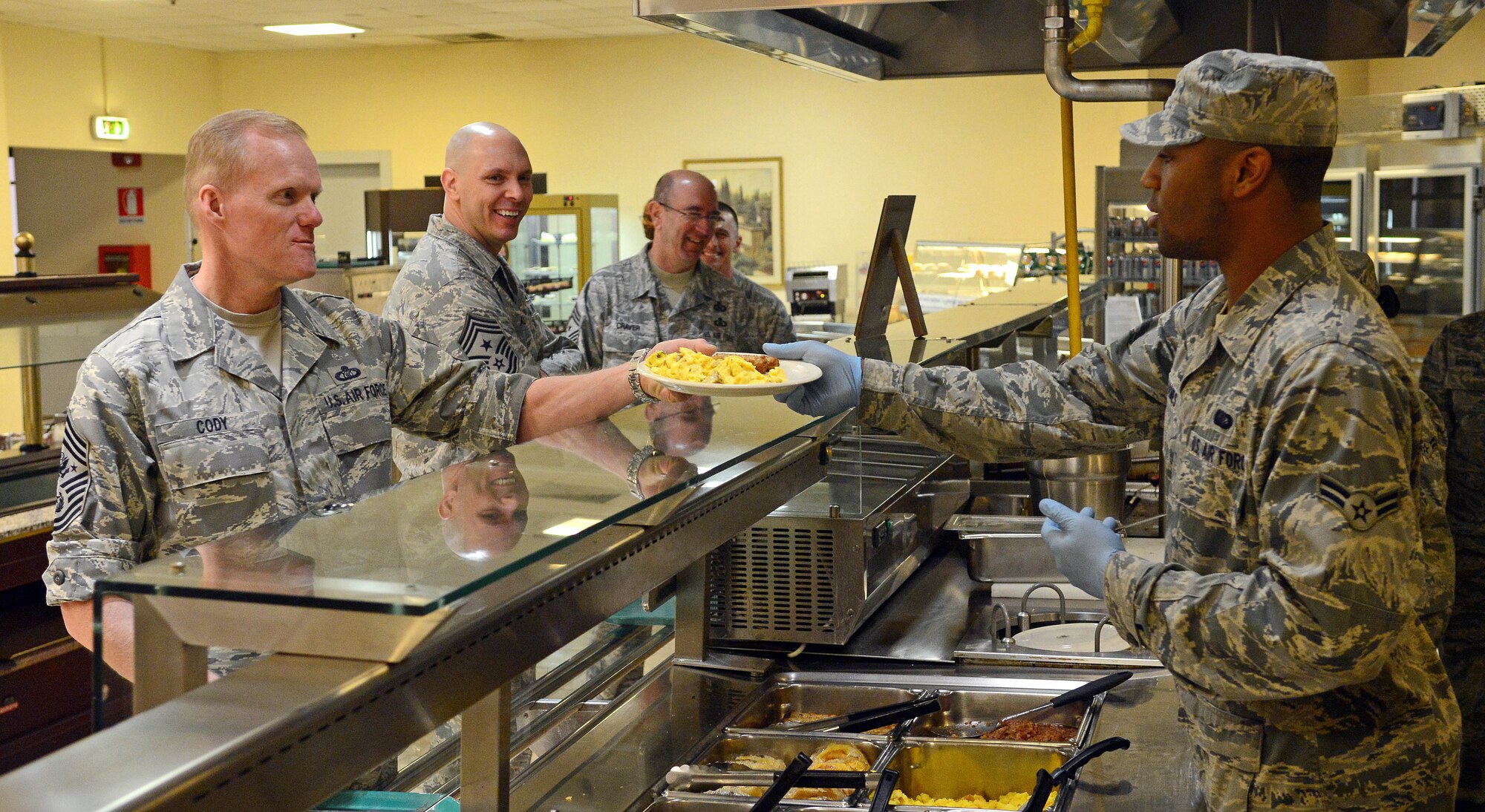 Airman 1st Class Davell James, 31st Force Support Squadron food service specialist, serves Chief Master Sgt. of the Air Force James Cody at Aviano Air Base, Italy, Mar. 29, 2013. Cody sat down to have breakfast with some of Aviano’s Airmen for them to ask questions such as suicide awareness, physical fitness and deployments. (U.S. Air Force photo/Airman 1st Class Matthew Lotz)