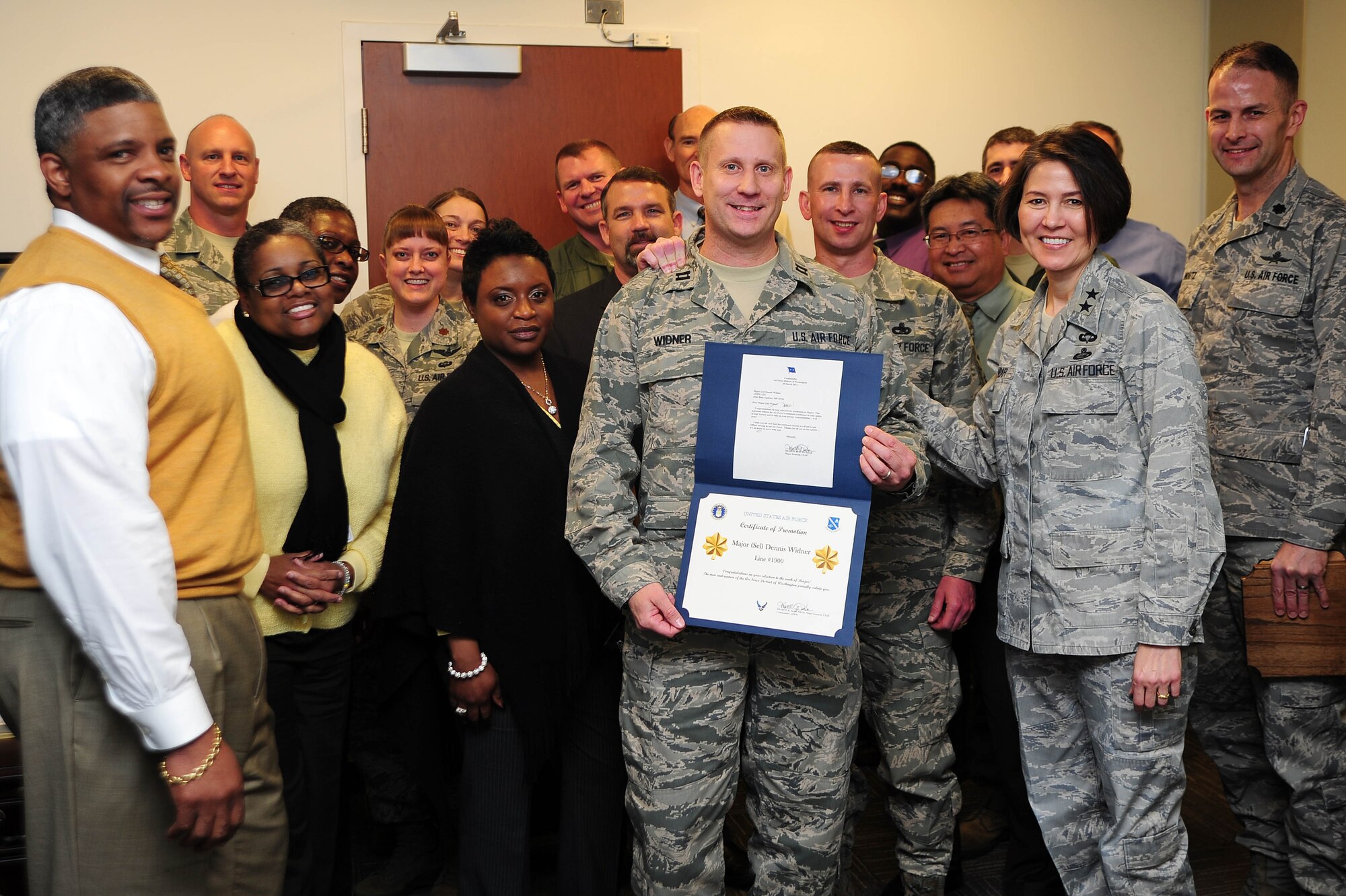 Air Force District of Washington Commander Maj. Gen. Sharon K. G. Dunbar and fellow Headquarters AFDW leadership and staff congratulate Capt. Dennis Widner, HQ AFDW Air, Space and Information Operations, upon being selected for promotion to the rank of major, March 27, 2013, at Joint Base Andrews, Md. Widner and fellow captains selected for promotion will pin on the bronze oak leaf clusters throughout the next year. (U.S Air Force photo by Senior Airman Steele C. G. Britton)