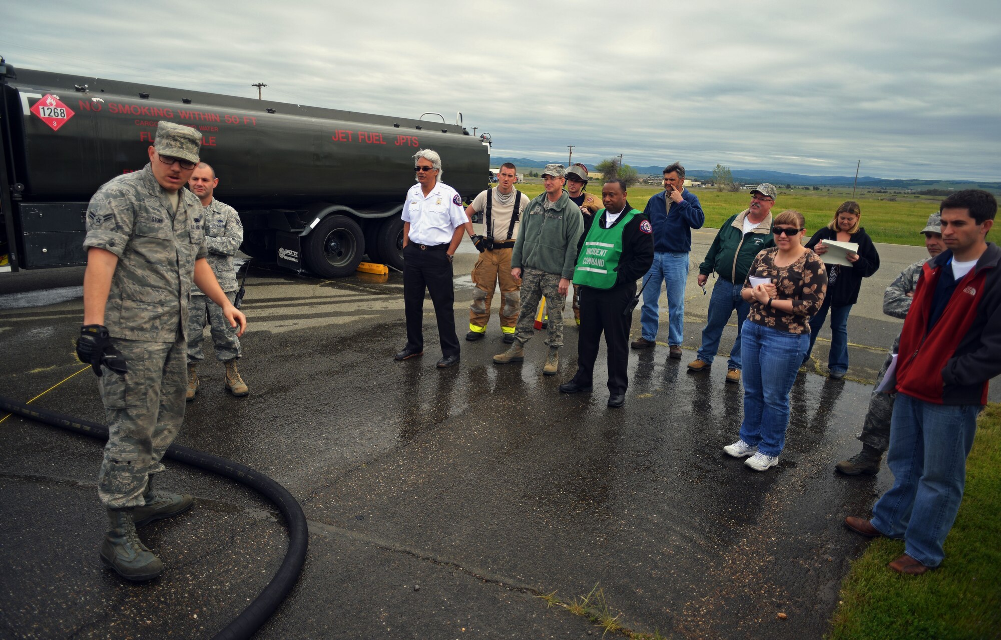 Airman 1st Class Trevor Story, 9th Logistics Readiness Squadron fuels distribution operator, explains how a fuel spill would be properly contained to inspectors and base personnel at Beale Air Force Base, Calif., March 28, 2013. The exercise demonstrates the response of personnel throughout the base to respond to real-world situations. (U.S. Air Force photo by Airman 1st Class Drew Buchanan/Released)
