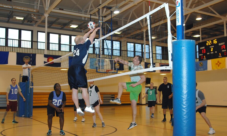 Jumping, Tech. Sgt. Jonathan Gambrell, Detachment 2 25th Intelligence Squadron NCO in charge of small computers from Myrtle Beach, S.C., blocks the ball during an intramural volleyball game between the 100th Operations Group and the 95th Reconnaissance Squadron March 28, 2013, at the Hardstand Fitness Center on RAF Mildenhall, England. The 100th OG was victorious over the 95th RS in both matches. (U.S. Air Force photo by Airman 1st Class Dillon Johnston/Released)