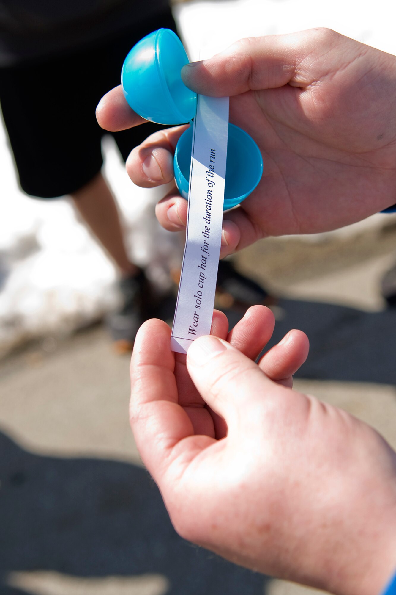 GRISSOM AIR RESERVE BASE, Ind. -- An Easter egg fun run participant opens a plastic egg at the beginning of the run to see what they will be required to wear during the event held here March 28. Teams had to stop at multiple stations during the three-mile run and complete holiday-themed tasks. (U.S. Air Force photo/Tech. Sgt. Mark R. W. Orders-Woempner)