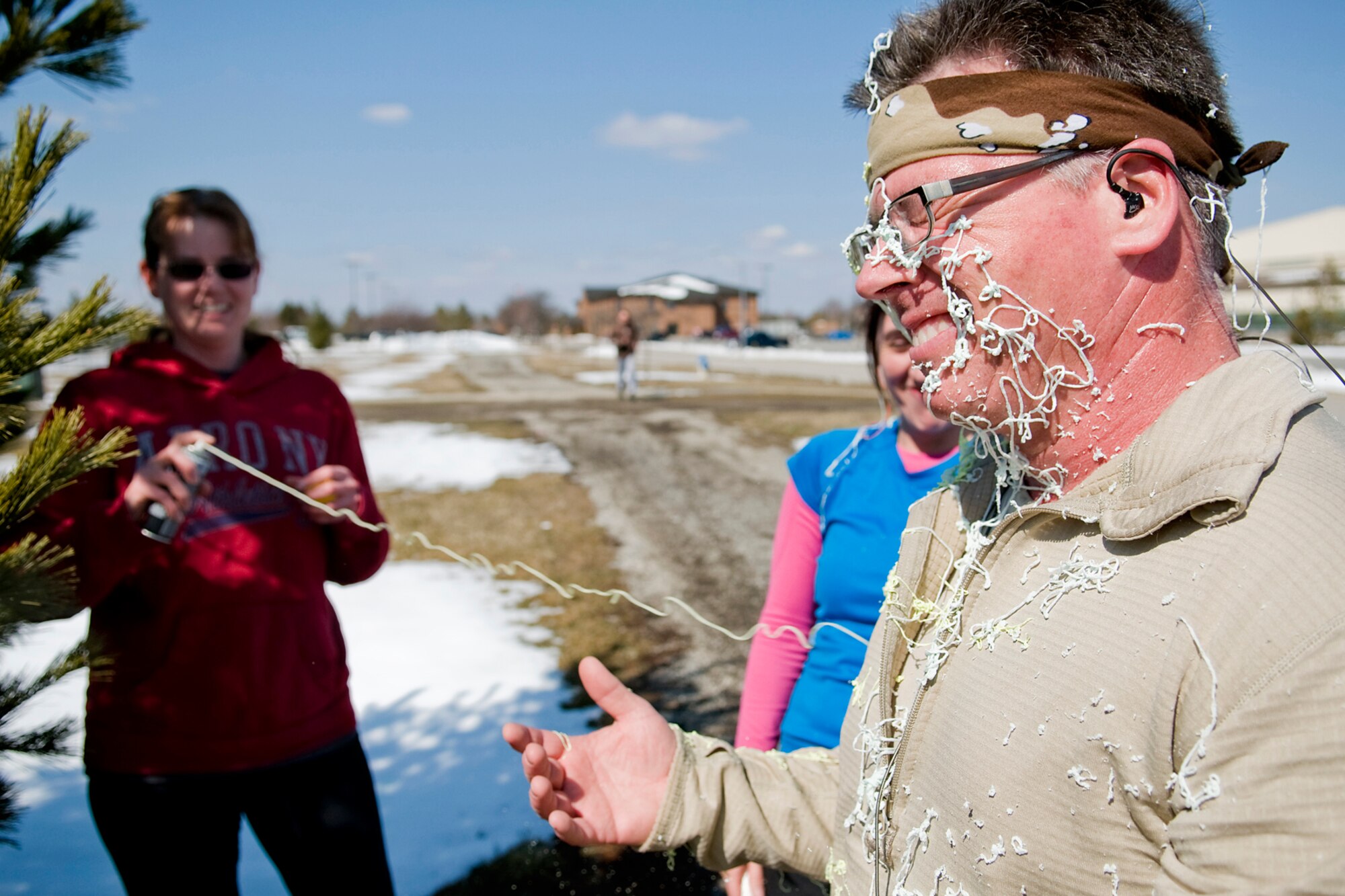 GRISSOM AIR RESERVE BASE, Ind. -- Doug Hays gets blasted in the face with aerosol string  by his team members during an Easter egg fun run held here March. 28. Teams had to stop at multiple stations during the three-mile run and complete holiday-themed tasks. (U.S. Air Force photo/Tech. Sgt. Mark R. W. Orders-Woempner)
