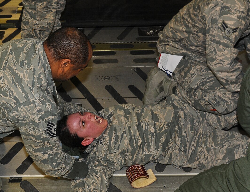 Airman 1st Class Xochil Avila, 446th Aeromedical Evacuation Squadron aeromedical technician, struggles as she is restrained. Avila was taking part in an emergency scenario in which she portrayed a disoriented and traumatized patient posing a threat to the flight crew. The scenario was part of initial certification training for aeromedical technicians. (U.S. Army photo/Spc. Loren Cook)


