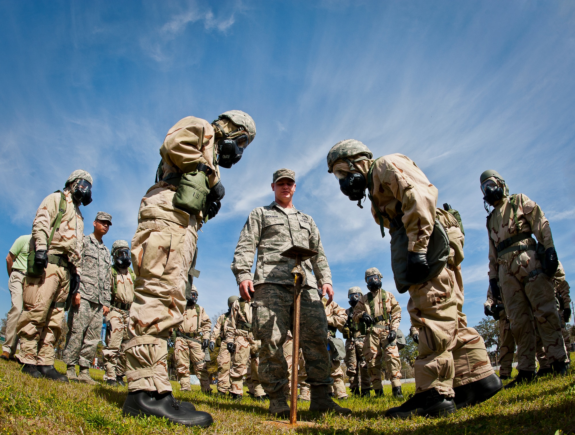 Staff Sgt. Ken Buchanan, of the 96th Civil Engineer Group, helps Airmen in MOPP-4 gear examine M8 contamination paper in their sector during the field training portion of a Phase II exercise March 21 at Eglin Air Force Base, Fla. A Phase II evaluates a unit's ability to meet wartime and contingency taskings of employing the force, sustaining the force and the ability to survive and operate.  More than 75 deployers, in two groups, received classroom and practical field training over March 20-21 to meet the readiness requirement.  (U.S. Air Force photo/Samuel King Jr.)