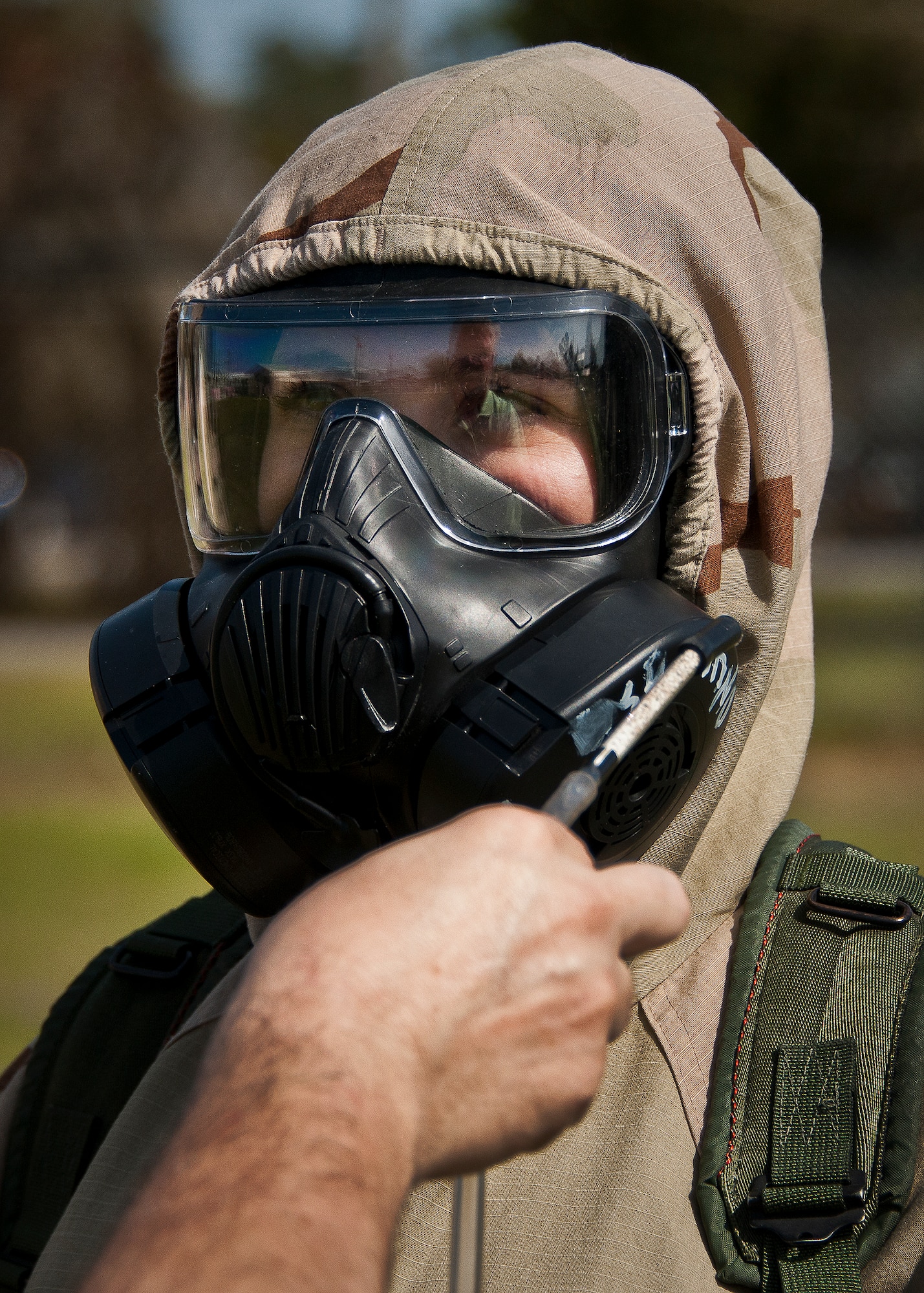 Michael Crow, a contractor with the Emergency Management Flight Support waves a smelling agent around Airman’s gas mask to ensure they fit and are sealed properly during the field training portion of a Phase II exercise March 21 at Eglin Air Force Base, Fla. A Phase II evaluates a unit's ability to meet wartime and contingency taskings of employing the force, sustaining the force and the ability to survive and operate.  More than 75 deployers, in two groups, received classroom and practical field training over March 20-21 to meet the readiness requirement.  (U.S. Air Force photo/Samuel King Jr.) 