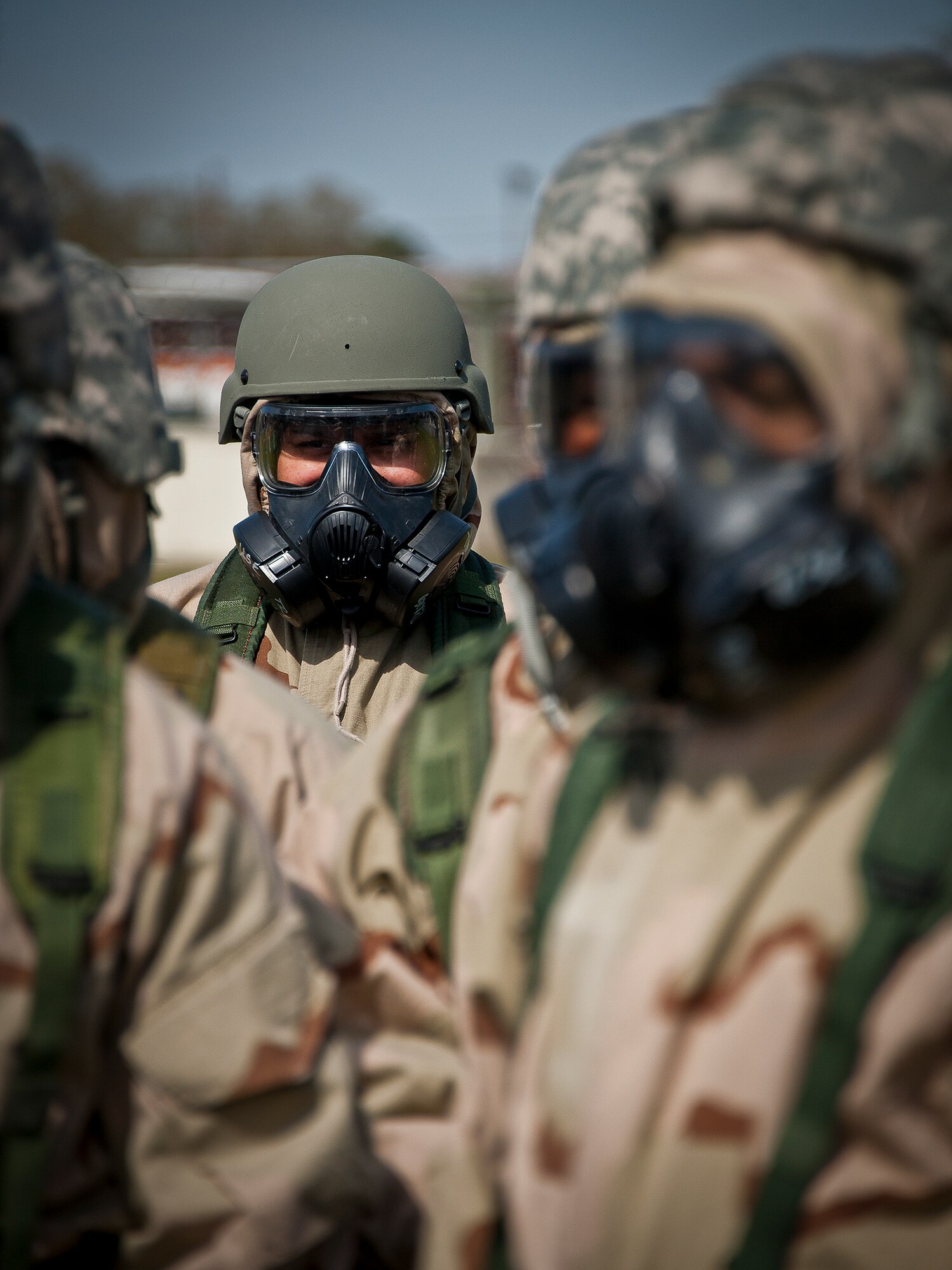 Airmen in MOPP-4 gear listen to their instructor talk about the next scenario during the field training portion of a Phase II exercise March 21 at Eglin Air Force Base, Fla. A Phase II evaluates a unit's ability to meet wartime and contingency taskings of employing the force, sustaining the force and the ability to survive and operate.  More than 75 deployers, in two groups, received classroom and practical field training over March 20-21 to meet the readiness requirement.  (U.S. Air Force photo/Samuel King Jr.) 