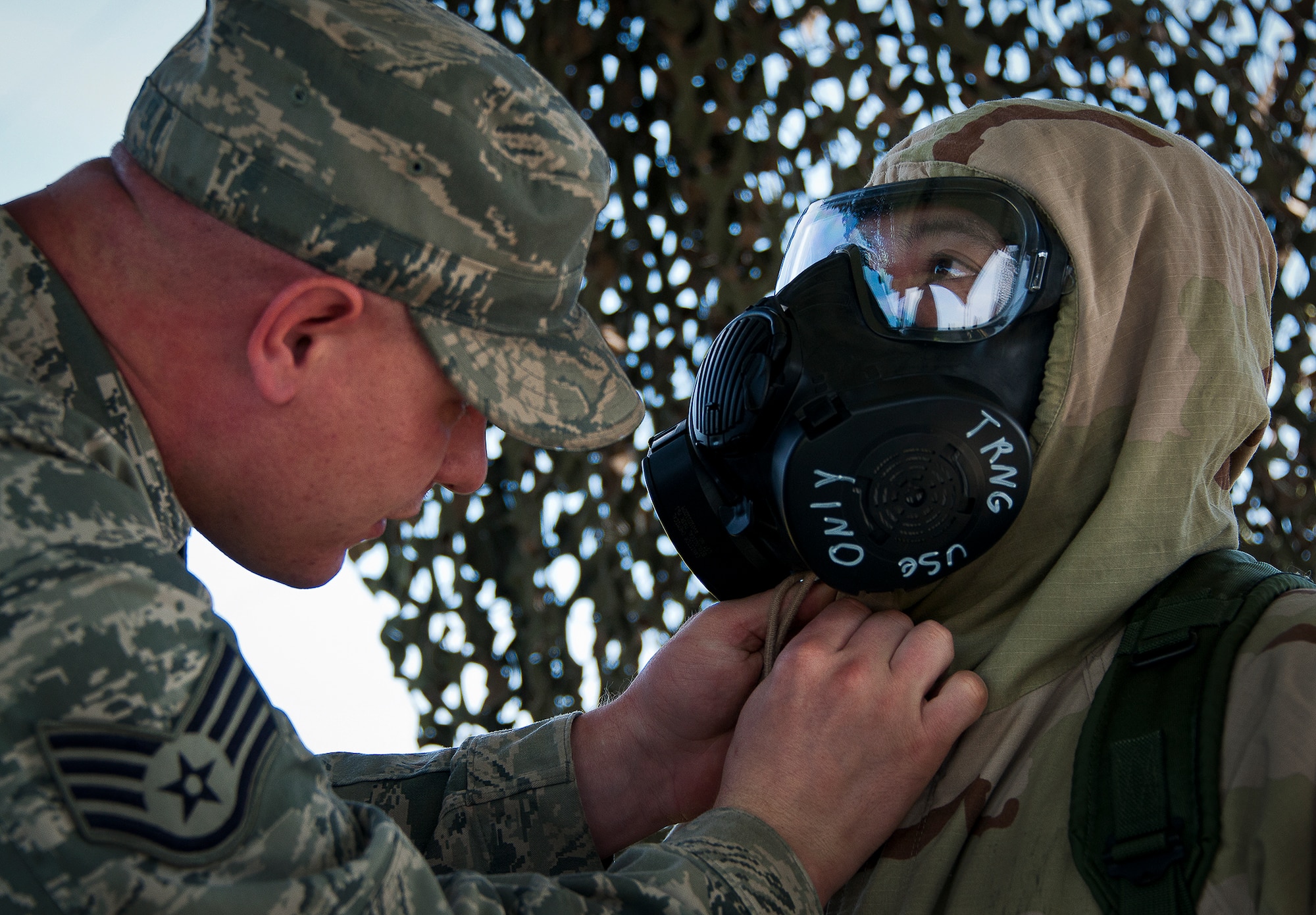 Staff Sgt. Ken Buchanan, of the 96th Civil Engineer Group, helps an Airman ensure her neck area is properly sealed during the field training portion of a Phase II exercise March 21 at Eglin Air Force Base, Fla. A Phase II evaluates a unit's ability to meet wartime and contingency taskings of employing the force, sustaining the force and the ability to survive and operate.  More than 75 deployers, in two groups, received classroom and practical field training over March 20-21 to meet the readiness requirement.  (U.S. Air Force photo/Samuel King Jr.) 