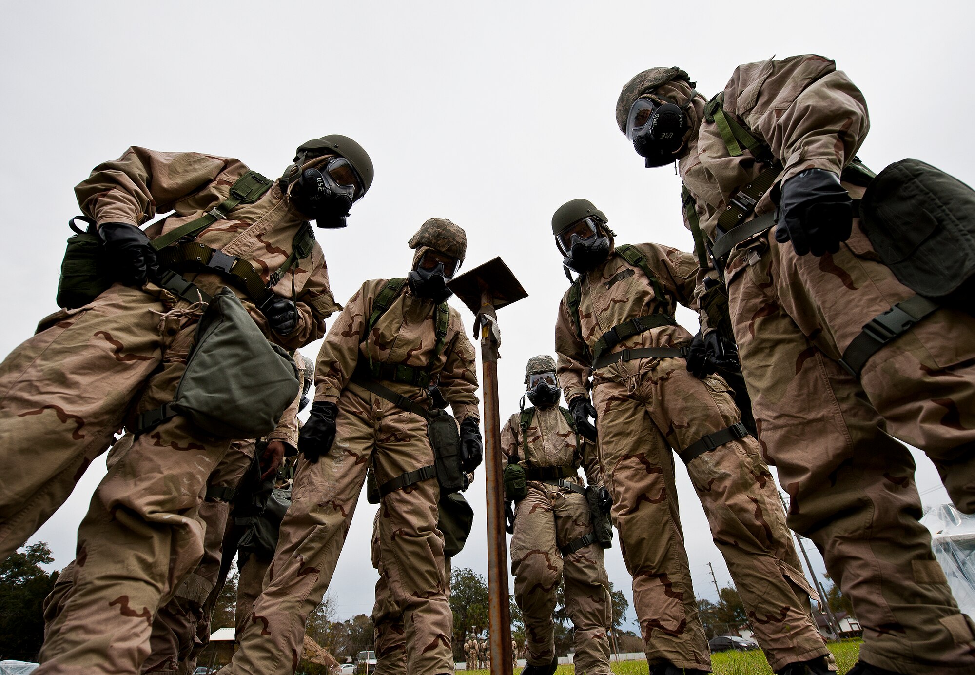 Airmen in MOPP-4 gear examine M8 contamination paper in their sector during the field training portion of a Phase II exercise March 20 at Eglin Air Force Base, Fla. A Phase II evaluates a unit's ability to meet wartime and contingency taskings of employing the force, sustaining the force and the ability to survive and operate.  More than 75 deployers, in two groups, received classroom and practical field training over March 20-21 to meet the readiness requirement.  (U.S. Air Force photo/Samuel King Jr.) 