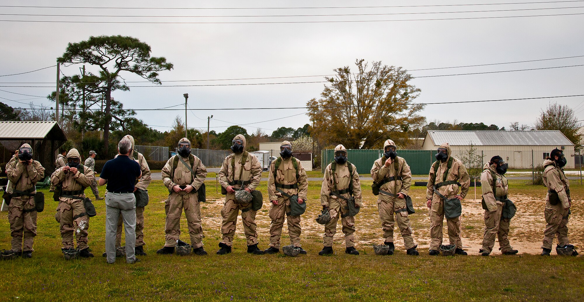 Michael Crow, a contractor with the Emergency Management Flight Support waves a smelling agent around Airmen’s gas masks to ensure they fit and are sealed properly during the field training portion of a Phase II exercise March 20 at Eglin Air Force Base, Fla. A Phase II evaluates a unit's ability to meet wartime and contingency taskings of employing the force, sustaining the force and the ability to survive and operate.  More than 75 deployers, in two groups, received classroom and practical field training over March 20-21 to meet the readiness requirement.  (U.S. Air Force photo/Samuel King Jr.) 